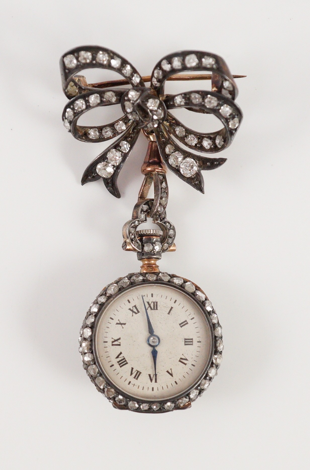 A late 19th century/early 20th century French 18ct gold and rose cut diamond encrusted fob lapel watch, on a rose cut diamond set ribbon bow suspension brooch
